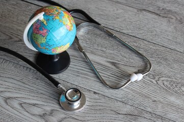 World Health Day, Global Healthcare, Medical Concept. Stethoscope and earth globe on wooden table.
