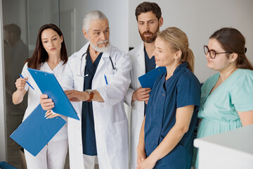 Doctor giving lecture to interns in hospital discussing patient diagnosis