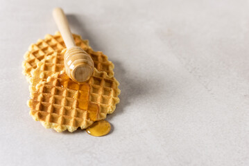 Honey Pouring on a Fresh Waffles Breakfast with Belgian Waffles Gray Background Copy Space