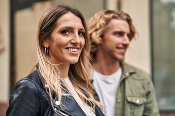 Man and woman couple smiling confident hugging each other at street