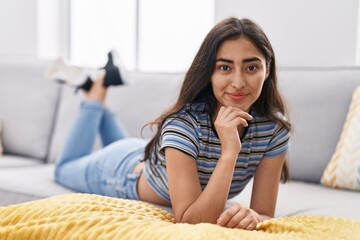 Obraz na płótnie Canvas Young hispanic girl smiling confident lying on sofa at home