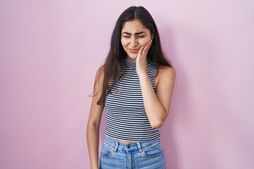 Young teenager girl wearing casual striped t shirt touching mouth with hand with painful expression because of toothache or dental illness on teeth. dentist