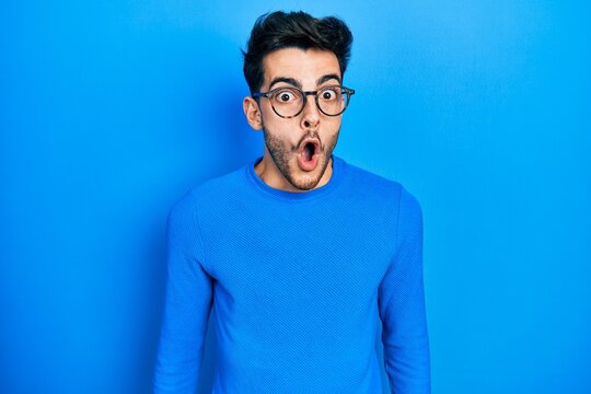 Young hispanic man wearing casual clothes and glasses afraid and shocked with surprise expression, fear and excited face.