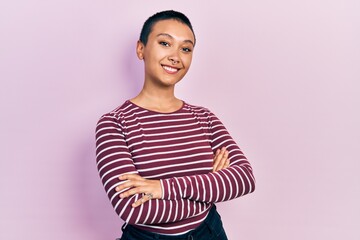 Beautiful hispanic woman with short hair wearing casual striped sweater happy face smiling with crossed arms looking at the camera. positive person.