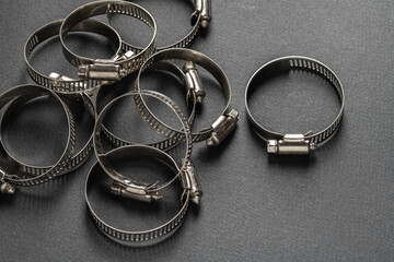 Metal hose clamp on black background. Empty space for text