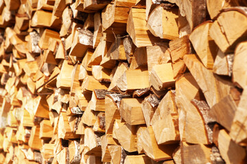 Textured firewood background of chopped wood for kindling and heating the house, a woodpile with stacked firewood. Concept of economic fuel crisis.