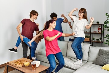 Group of young hispanic friends having party dancing at home.