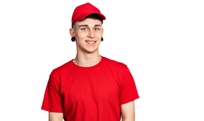 Young caucasian boy with ears dilation wearing delivery uniform and cap looking positive and happy standing and smiling with a confident smile showing teeth