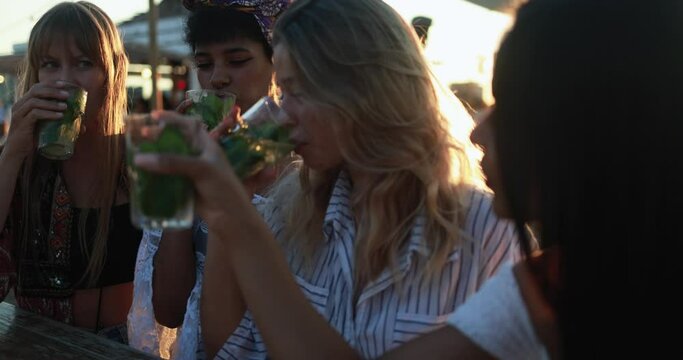 Happy multiracial girls having fun drinking mojitos at beach party outdoor