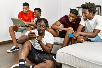 Group of african american people smiling happy using smartphone and laptop at home.