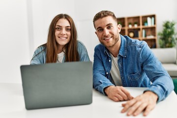 Fototapeta na wymiar Young caucasian couple smiling happy using laptop at home.