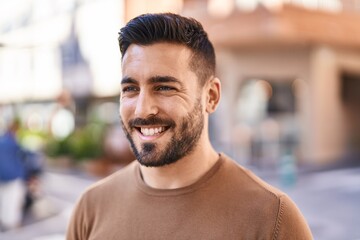 Fototapeta premium Young hispanic man smiling confident standing at street