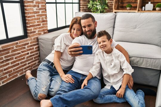 Family make selfie by smartphone sitting on floor at home