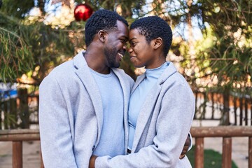 Man and woman couple hugging each other standing at park