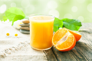 Fototapeta na wymiar A glass of tangerine juice and a ripe juicy tangerine on a table