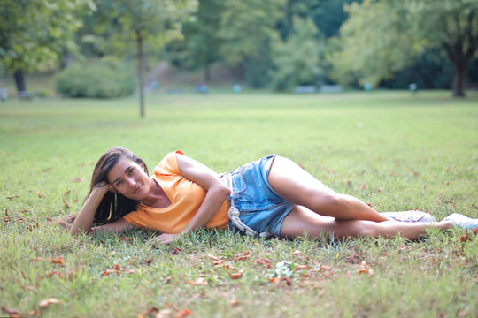 young woman lying on the grass in a park
