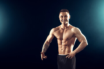 Fototapeta premium Power, strength, excellent body, bodybuilding, sports concept. Young handsome muscular fit man demonstrating perfect body