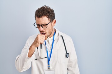 Young hispanic man wearing doctor uniform and stethoscope feeling unwell and coughing as symptom for cold or bronchitis. health care concept.