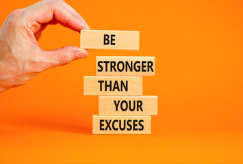 Be stronger symbol. Concept words Be stronger than your excuses on wooden blocks on a beautiful orange table orange background. Businessman hand. Business motivational and be stronger concept.
