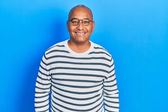 Middle age latin man wearing casual clothes and glasses with a happy and cool smile on face. lucky person.