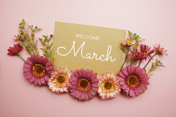 Fototapeta na wymiar Welcome March typography text with flowers on pink background