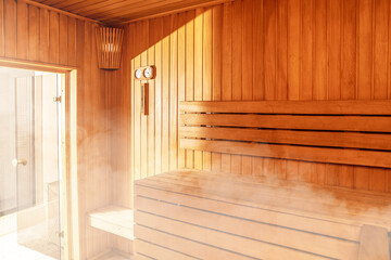 Obraz na płótnie Canvas Interior of Finnish sauna, classic wooden sauna with hot steam. Russian bathroom. Relax in hot sauna with steam. Wooden interior baths, wooden benches and loungers accessories for sauna, spa complex