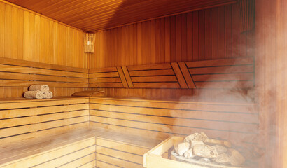 Fototapeta na wymiar Interior of Finnish sauna, classic wooden sauna with hot steam. Russian bathroom. Relax in hot sauna with steam. Wooden interior baths, wooden benches and loungers accessories for sauna, spa complex