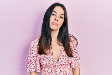 Obraz premium Young brunette woman wearing summer dress relaxed with serious expression on face. simple and natural looking at the camera.