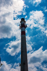 Obraz premium Factory chimney against a cloudy sky. Air pollution from smoke coming out of factory chimneys. The concept of air pollution, environmental problems, atmospheric emissions.