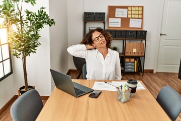 Middle age hispanic woman stretching and relaxing at office
