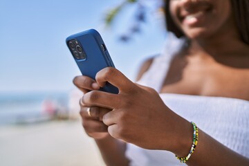 Young african american girl smiling happy using smartphone at the promenade.