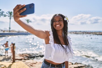 Young african american girl smiling happy make selfie by the smartphone at the beach.