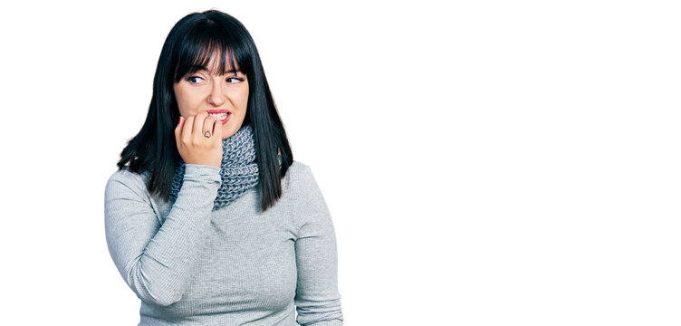 Young hispanic plus size woman wearing winter scarf looking stressed and nervous with hands on mouth biting nails. anxiety problem.
