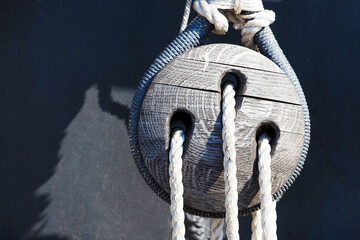 Old ship pulley on old sailing wooden ship. Wooden fasteners. Rigging on an old wooden frigate or...