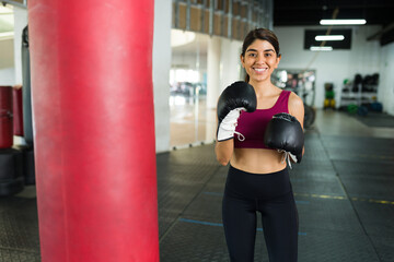 Hispanic woman at the gym next to a punching bag