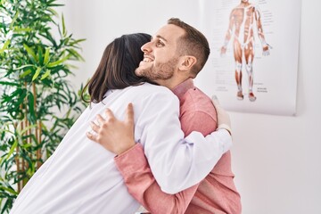 Man and woman doctor and patient hugging each other at clinic