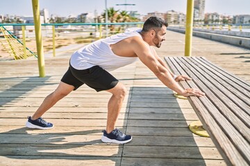 Obraz premium Hispanic man stretching after working out outdoors on a sunny day