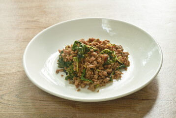 spicy stir fried chop pork with chili and basil leaf on plate 