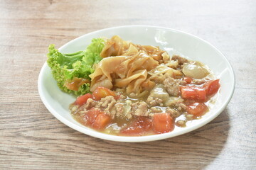 stir fried large rice noodles black soybean dressing chop pork and vegetable in gravy sauce on plate