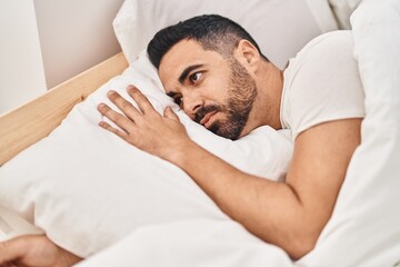 Fototapeta na wymiar Young hispanic man suffering insomnia lying on bed at bedroom