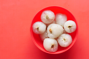 Lychee on in a bowl on red background 