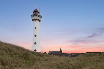 White lighthouse in the dunes in the small Dutch village of Egmond aan Zee.