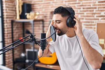 Young arab man artist singing song at music studio