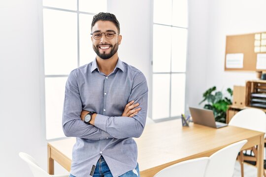 Young arab man smiling confident standing with arms crossed gesture at office
