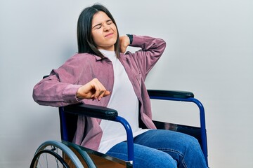 Fototapeta na wymiar Young brunette woman sitting on wheelchair stretching back, tired and relaxed, sleepy and yawning for early morning