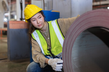  Asian female workers wear red helmet working check up iron production in factory. Heavy Industrial manufacturing workplace. woman engineer professional machinery workshop.