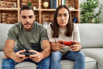 Young latin couple frustrated playing video game at home. © Krakenimages.com