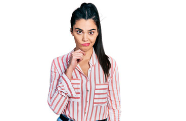 Young hispanic woman wearing casual clothes thinking concentrated about doubt with finger on chin...