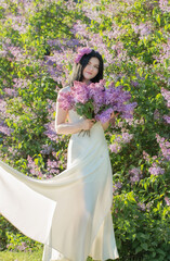 young girl with blooming lilac in sunlight
