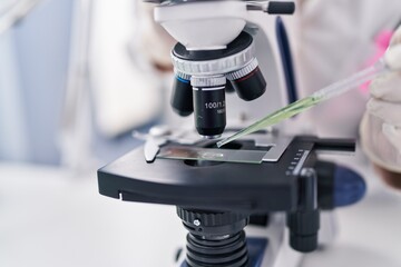 Young woman scientist using microscope working at laboratory